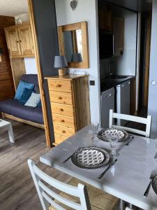 a dining table and chairs in a room with a bedroom at Résidence Gollet - Studio pour 4 Personnes 884 in Valmorel