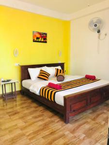 a large bed in a room with a yellow wall at Green Horizon Ella in Ella