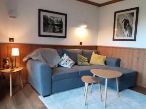 salon z niebieską kanapą i dwoma stołami w obiekcie Résidence Valeriane - La Valériane 103 - Très beau 2 pièces avec vue dégagée sur la vallée MAE-6304 w mieście Valmorel