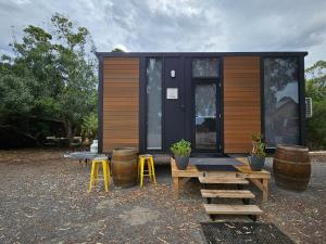 a tiny house with a picnic table and stools at Alma Tiny House in Willunga