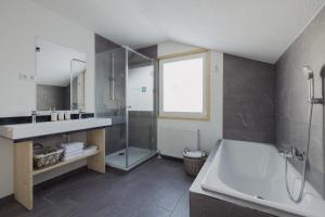 La salle de bains est pourvue d'une baignoire, d'un lavabo et d'une douche. dans l'établissement Ferienhaus Streif LXL, à Kirchdorf in Tirol