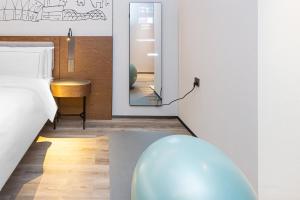 Voodi või voodid majutusasutuse UrCove by Hyatt Foshan Downtown toas