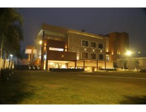 un gran edificio por la noche con un campo de césped en Hotel Golden Palm, Gurdaspur, en Gurdāspur