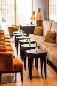 a living room with couches and tables and chairs at Caravelle Hotel im Park in Bad Kreuznach