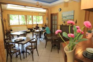 a restaurant with tables and chairs and people sitting at tables at IKAROS Hotel ELLINIKO in Athens