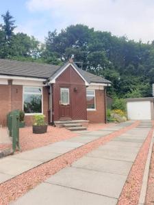 una pequeña casa con una acera delante de ella en Eliburn Woodside Lodge, en Livingston