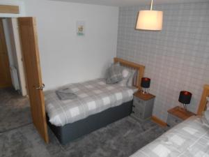 a small bedroom with two beds and a lamp at Eliburn Woodside Lodge in Livingston