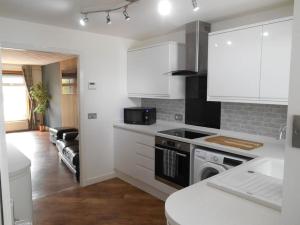 a kitchen with white cabinets and a stove top oven at Eliburn Woodside Lodge in Livingston