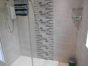 a shower with a glass door in a bathroom at Eliburn Woodside Lodge in Livingston