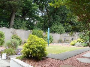Eliburn Woodside Lodge في ليفينغستون: حديقة بها سياج و عمود ازرق