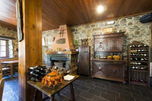 Habitación con chimenea y mesa con botellas de vino. en Hotel Rural Valle de Ancares, en Pereda de Ancares