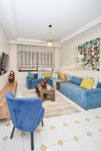 un soggiorno con divani blu e un tavolo di Cozy 2 BR Gauthier Oasis a Casablanca