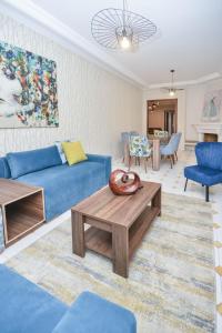 un soggiorno con divano blu e tavolo di Cozy 2 BR Gauthier Oasis a Casablanca