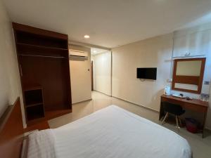 a bedroom with a bed and a desk and a television at Aeton Hotel Nilai in Nilai