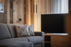 ein Wohnzimmer mit einem Sofa und einem Flachbild-TV in der Unterkunft Rueper Hof Chalet Ruipa in Olang