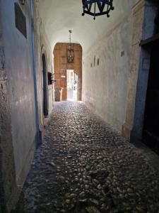 an empty alley with a stone floor and a chandelier at Dimora Palatina in Tivoli