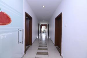 a hallway with white walls and wooden doors at OYO Hotel Pearl View Residency in Ambalavayal