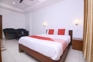 a bedroom with a large bed with red pillows at OYO Hotel Pearl View Residency in Ambalavayal