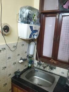 uma cozinha com um lavatório, um armário e uma janela em Deer park Studio Flat (1 BHK) em Nova Deli