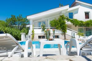 a white table and chairs in front of a house at Vacation Home Mirasole in Mostar