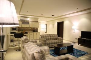فندق ميلانا Milana Hotel في جدة: غرفة معيشة مع كنبتين ومطبخ