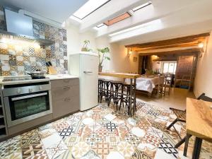 een keuken met een koelkast en een tafel met stoelen bij Unik Vacation Ca La Lola in Nulles