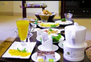 un tavolo con piatti di cibo e una bevanda di فندق ميلانا Milana Hotel a Gedda