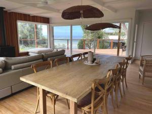 a living room with a wooden table and chairs at The Dunes *Beachfront* Lake Tyers Beach in Lake Tyers