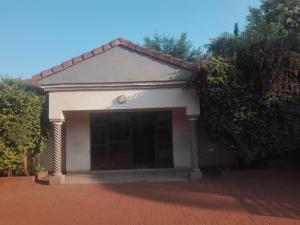 ein Gebäude mit einer großen Garage auf einer gemauerten Auffahrt in der Unterkunft DZUVHA VILLAGE INN in Thohoyandou