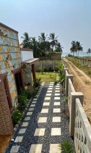 a stone path leading to a house with palm trees at The Inner Chambers in Prampram