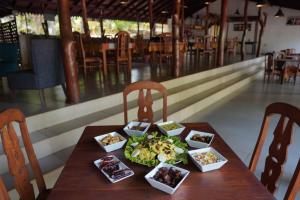 a wooden table with plates of food on it at Star Dambulla in Dambulla