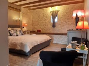 a bedroom with a bed and a table with a lamp at Domaine Les Feuillants in Crouzilles +22 photos