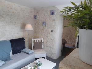een woonkamer met een bank en een potplant bij Domaine Les Feuillants in Crouzilles