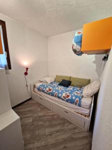 a small bedroom with a bed with a blue comforter at Résidence Edelweiss - 2 Pièces pour 4 Personnes 684 in Risoul