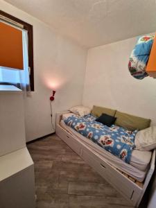 a small bedroom with a bed with a blue comforter at Résidence Edelweiss - 2 Pièces pour 4 Personnes 684 in Risoul