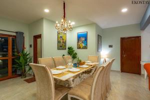 a dining room with a table and chairs and a chandelier at Ekostay Gold- Aqua Beach Villa I Partial Sea View I 1 min Walk to the Beach in Candolim