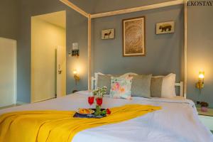 a white bed with a yellow blanket on it at Ekostay Gold- Aqua Beach Villa I Partial Sea View I 1 min Walk to the Beach in Candolim