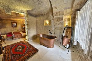 a large bathroom with a copper tub in a room at Divan Cave House in Goreme