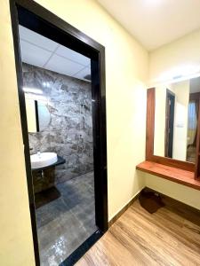 a bathroom with a shower and a sink and a mirror at S K Legacy Hotel in Mysore