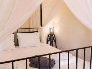 a small bedroom with a bed with a canopy at Villa in Santorini with Stunning Outdoor Kitchen in Megalokhori