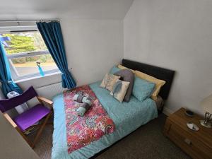 a bedroom with a bed and a chair and a window at Scotts Lodge Newcastle County Down in Newcastle