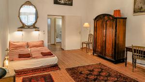 a bedroom with a bed and a mirror on the wall at La Vie En Rose: Elegance and Art in Berlin