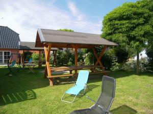 a wooden picnic table and chairs in a yard at Ferienpark Neppermin Appartmenthäuser in Neppermin