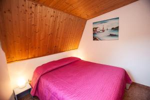 a bedroom with a bed with a pink blanket at Fantastic three-room penthouse - Beahost Rentals in Rosolina Mare