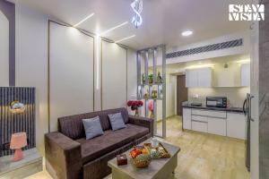 a living room with a couch and a kitchen at StayVista at Cityscape with Rooftop Pool - Jaipur in Jaipur