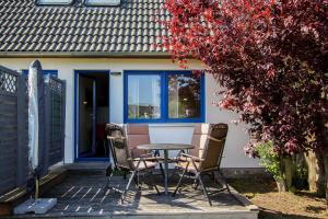 una mesa y sillas en un patio frente a una casa en Dat blaue Huus - Am Tor zum Darß en Pruchten