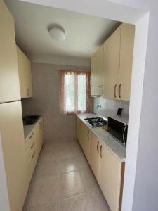 a kitchen with white cabinets and a stove top oven at Spacious apartment with terrace - Beahost Rentals in Rosolina Mare