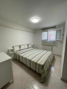 a bedroom with a bed in a white room at Spacious apartment with terrace - Beahost Rentals in Rosolina Mare