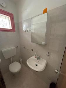 a bathroom with a white toilet and a sink at Spacious apartment with terrace - Beahost Rentals in Rosolina Mare