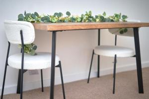 a wooden table with two chairs and a plant at Cozy Apartment in Birchwood in Risley